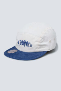 Boné cor areia da Chronic com aba de sarja aveludada e estampas em azul, visto de frente levemente inclinado para a esquerda.