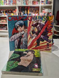 Pilha com vários volumes do mangá Chainsaw Man, mostrando as capas com o protagonista Denji e personagens como Power e Aki.