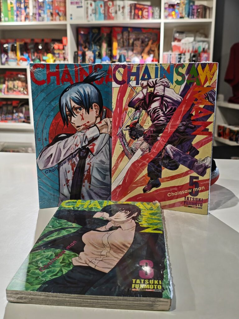 Pilha com vários volumes do mangá Chainsaw Man, mostrando as capas com o protagonista Denji e personagens como Power e Aki.
